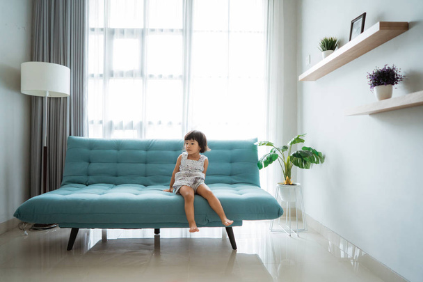little girl sitting on a comfortable sofa - Foto, Imagen