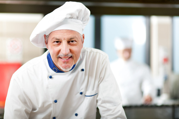 Smiling chef in his kitchen - Foto, afbeelding