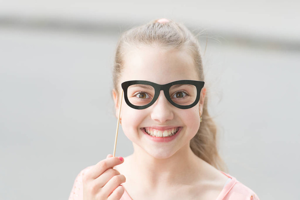 Give every child a happy childhood. Adorable small child with happy smile and funny look through glasses props. Happy little girl with big smile on summer day. Happy international childrens day - Photo, Image