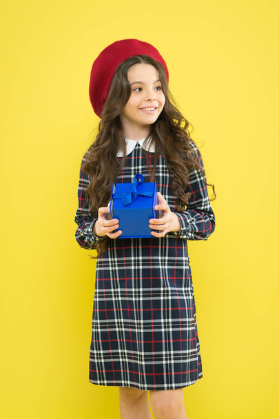 shopping. child with present box. happy birthday. . Holiday gift. parisian child on yellow background. happy girl with long curly hair in beret. small girl in french style hat. Choosing the best - Zdjęcie, obraz