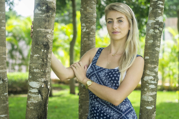 Chica ojos azules y piel blanca en el jardín sosteniendo el árbol medio sho
 - Foto, imagen