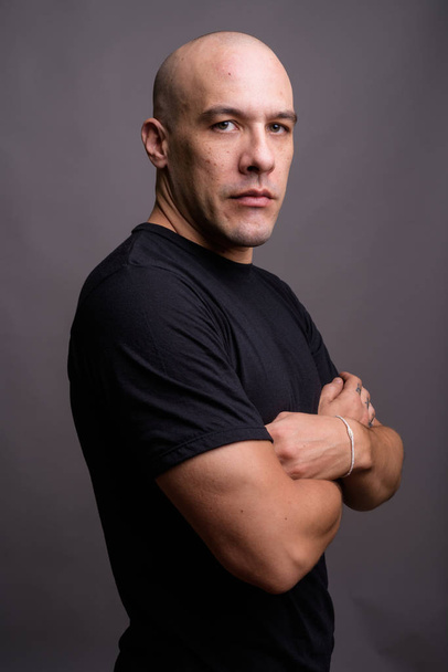 Portré jóképű kopasz férfi szürke háttér - Fotó, kép