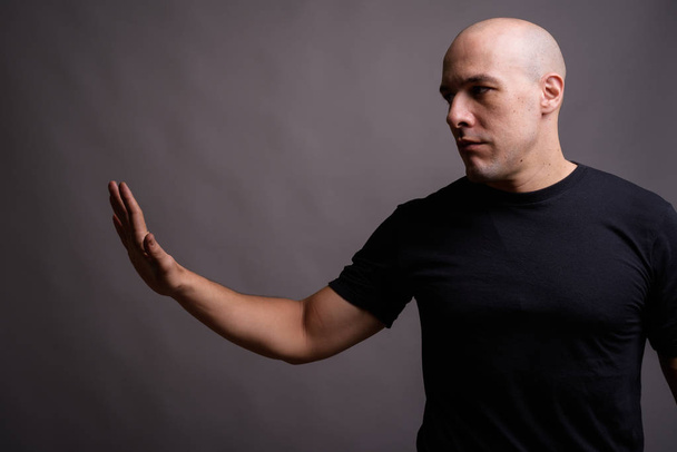 Portrait of handsome bald man against gray background - Fotoğraf, Görsel