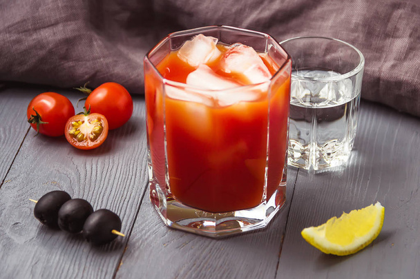 Cocktail Bloody Mary with ice in glasses on gray wooden table. - Φωτογραφία, εικόνα