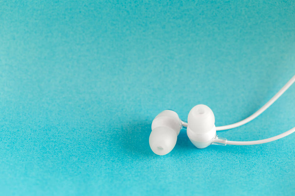White earbuds on blue colorful background with copy space for text - Foto, imagen