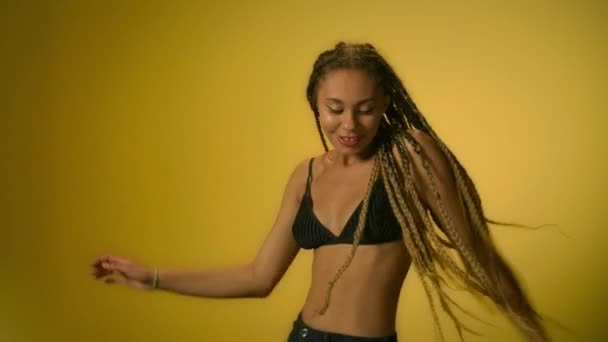 Танцююча дівчина танцює в студії з жовтою стіною. Африканська жінка танцює - Кадри, відео