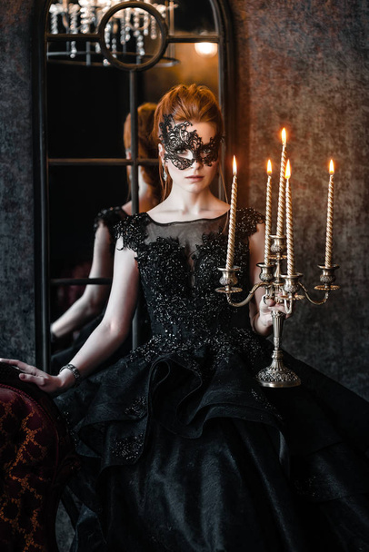 Attractive woman in black dress in medieval interior - Photo, Image