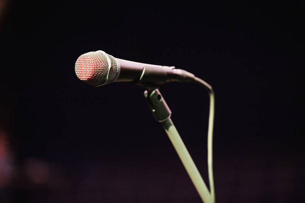 Microfoon op het podium tegen een achtergrond van auditorium. - Foto, afbeelding