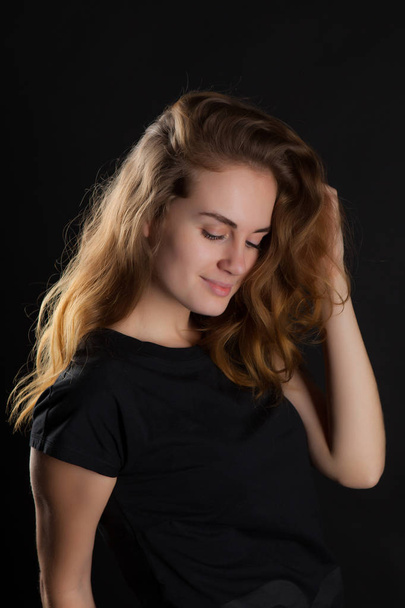 closeup portrait of a young, beautiful woman on a black background - Foto, afbeelding