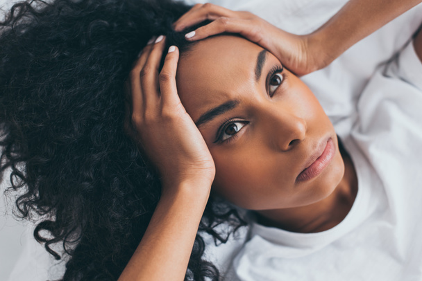 beautiful african american woman looking up while suffering from headache - 写真・画像