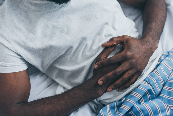 cropped view of african american man suffering from abdominal pain  - 写真・画像