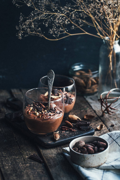 Chocolademousse in glas met lepel op houten achtergrond - Foto, afbeelding