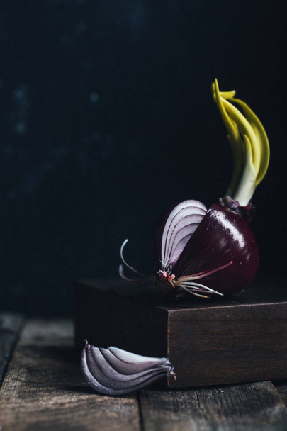fresh onion on dark wooden background, focus on foreground - Photo, image