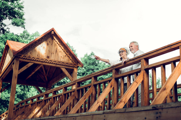 Cheerful spouse standing on the bridge with handsome man - Foto, afbeelding