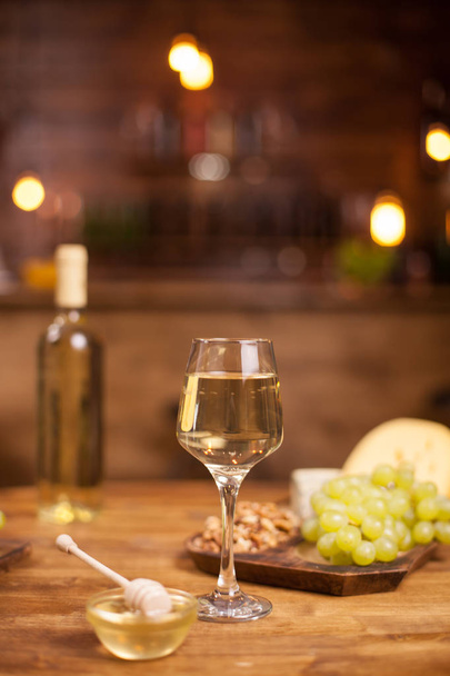 Wijnproeverij in een vintage pub met verse druiven op een houten tafel - Foto, afbeelding