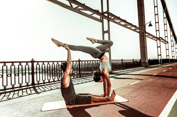 Strong girl doing a handstand on the bridge - Photo, image