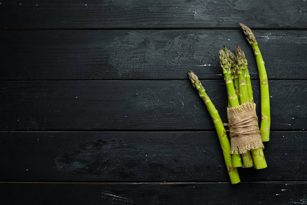 Green asparagus. Fresh asparagus on a black background. Top view. Free space for your text. - Fotografie, Obrázek