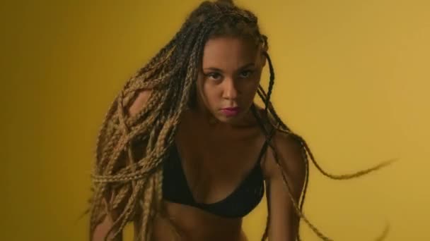 Expressive woman with afro dreadlocks dancing in studio front camera - Footage, Video