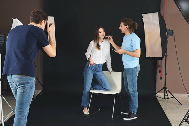 Photographer, makeup artist and model in modern studio - Photo, Image