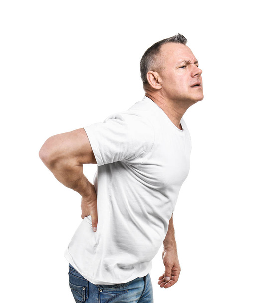 Csinos középkorú férfi szenved hátfájástól fehér alapon - Fotó, kép