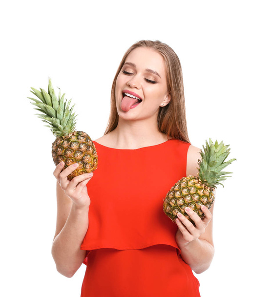 Beautiful young woman with pineapples on white background - Foto, imagen
