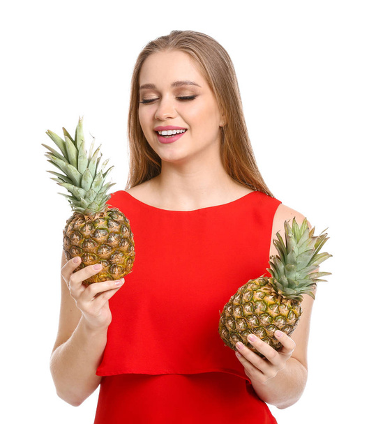 Beautiful young woman with pineapples on white background - Zdjęcie, obraz