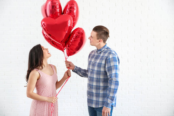 Jovem casal feliz com balões de ar no fundo branco
 - Foto, Imagem
