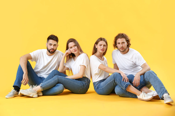 Stylish young people in jeans on color background - Фото, изображение