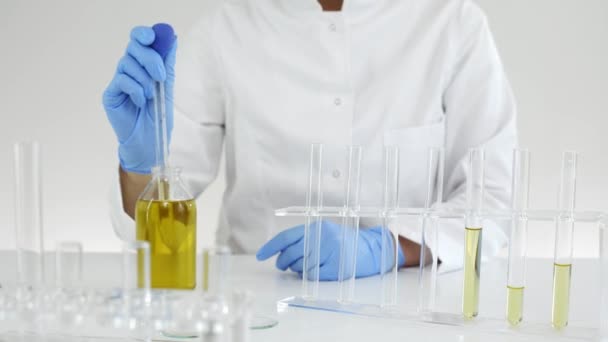 Vrouwelijke wetenschapper in laboratoriumtesten CBD olie geëxtraheerd uit een marihuana plant. Ze gebruikt een glas druppelaar en een buisje voor het experiment. Gezondheidszorg apotheek van medicinale cannabis. - Video