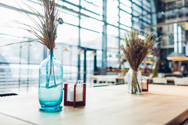 Centre commercial café design d'intérieur. Table décorée de vases pleins de verre sec avec des bougies
. - Photo, image
