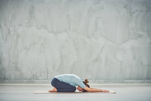 Fit Caucasian brunette doing Extended Child's yoga exercise.  - Photo, Image