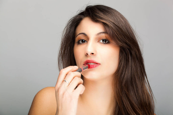 brunette woman applying lipstick - Foto, Imagem