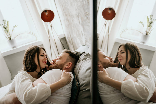 Couple in love in the bedroom. Slender brunette. Stylish interior. - Valokuva, kuva