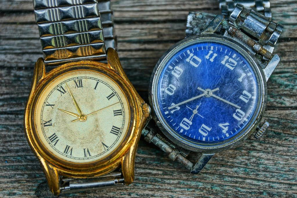 dos amarillo y azul viejo reloj de mala calidad con una correa de metal
 - Foto, Imagen