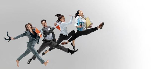 Office workers jumping isolated on studio background - Photo, image
