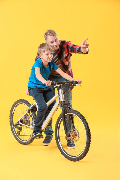 Baba ve oğlu renkli arka planda bisiklet ile - Fotoğraf, Görsel