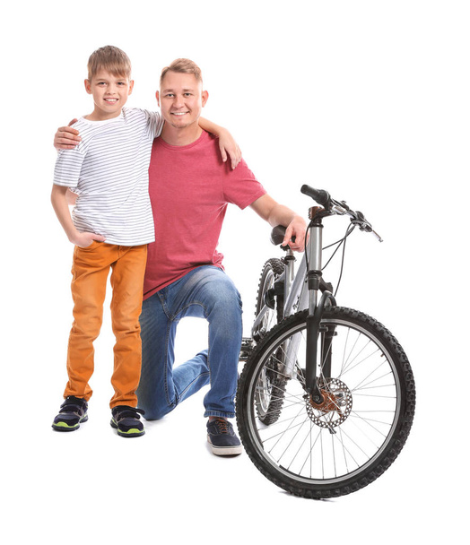 Father and his son with bicycle on white background - Фото, изображение