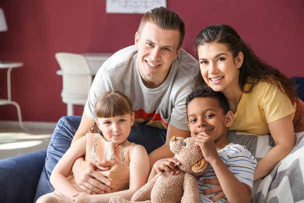 Happy couple with adopted children at home - Photo, Image