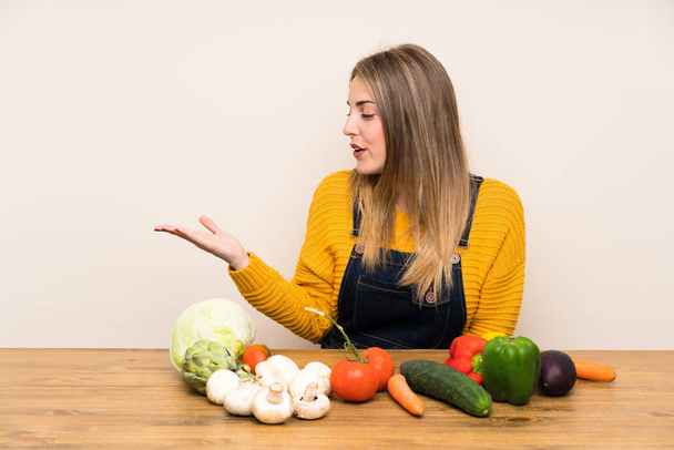 Vrouw met veel groenten met copyspace imaginair op de palm - Foto, afbeelding