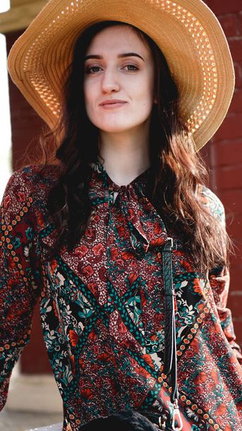 Portrait of pretty woman wearing dress and straw hat in sunny warm weather day - Фото, зображення
