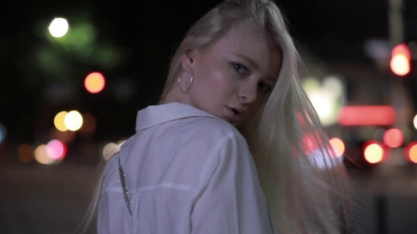 Mujer sexy con el pelo largo a su vez la cara en la ciudad de noche
 - Metraje, vídeo