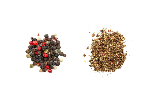 Twee stapels peper mix: graan en gemalen. Een mix van vier soorten peperkorrel: zwart, wit, roze, groen. Close-up bovenaanzicht. Geïsoleerd op witte achtergrond - Foto, afbeelding