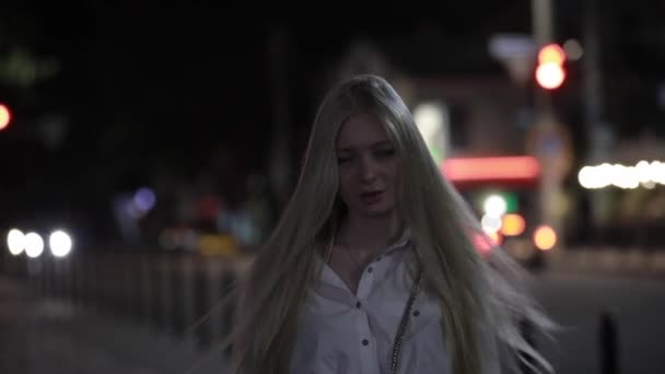 Blondine mit langen Haaren bläst Kuss in der Nacht Stadt - Filmmaterial, Video