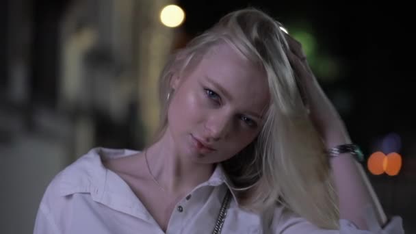 Pretty blonde model posing touching long hair in night city - Footage, Video