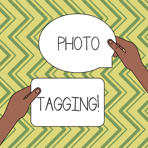 Texte d'écriture Word Photo Tagging. Concept d'entreprise pour identifier quelqu'un sur la photo que vous partagez les médias sociaux Deux tablettes Figurées Signes tenus dans les mains un au-dessus de l'autre espace de texte
. - Photo, image