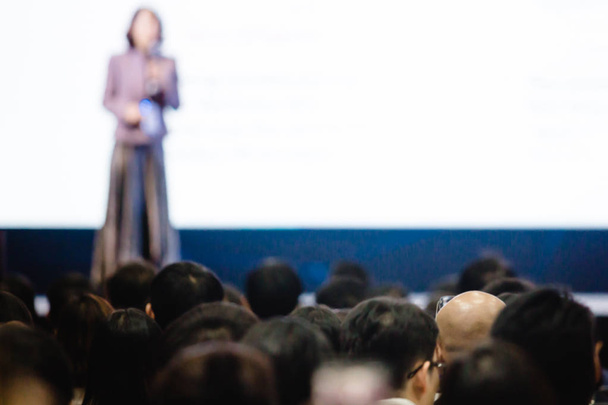 Blurry de oradora mujer discurso en el escenario en el auditorio para shareh
 - Foto, imagen