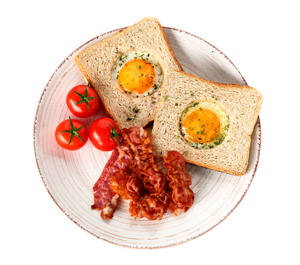 Plato con sabrosos huevos fritos, tocino, tostadas y tomate sobre fondo blanco
 - Foto, Imagen