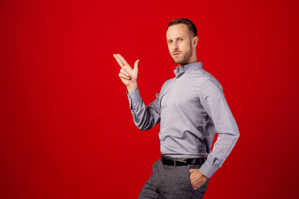 man making gun gesture over red background. people, business e a - Valokuva, kuva