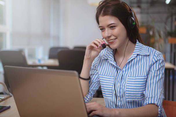 Friendly customer support operator with headset working at call  - 写真・画像