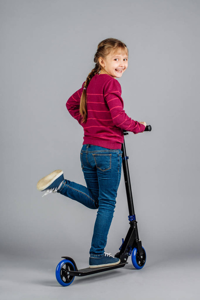 девушка с черным скутером на сером фоне
 - Фото, изображение